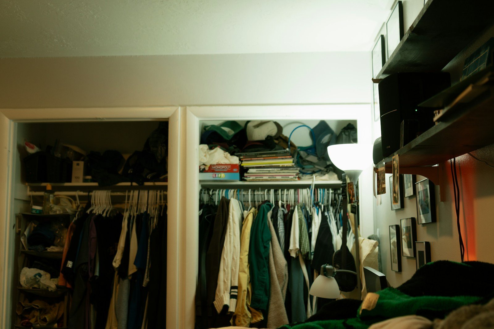Overstuffed reach-in closet with clothes and boxes piled up