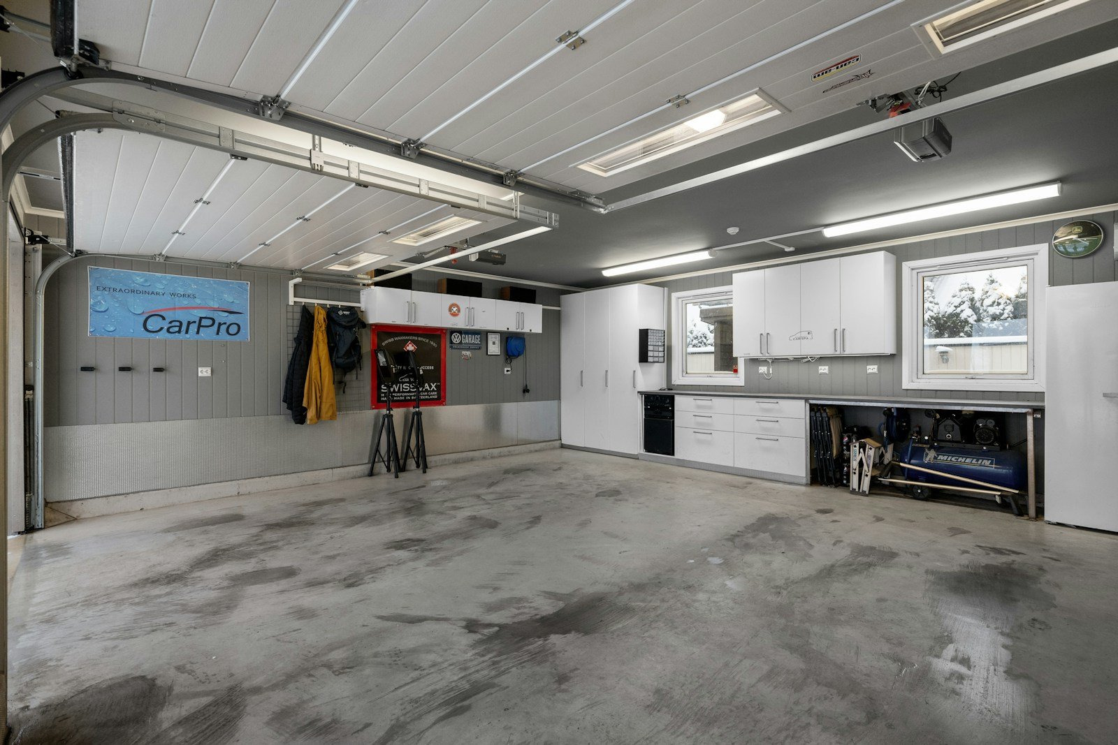 Garage with white custom cabinets and a clean floor