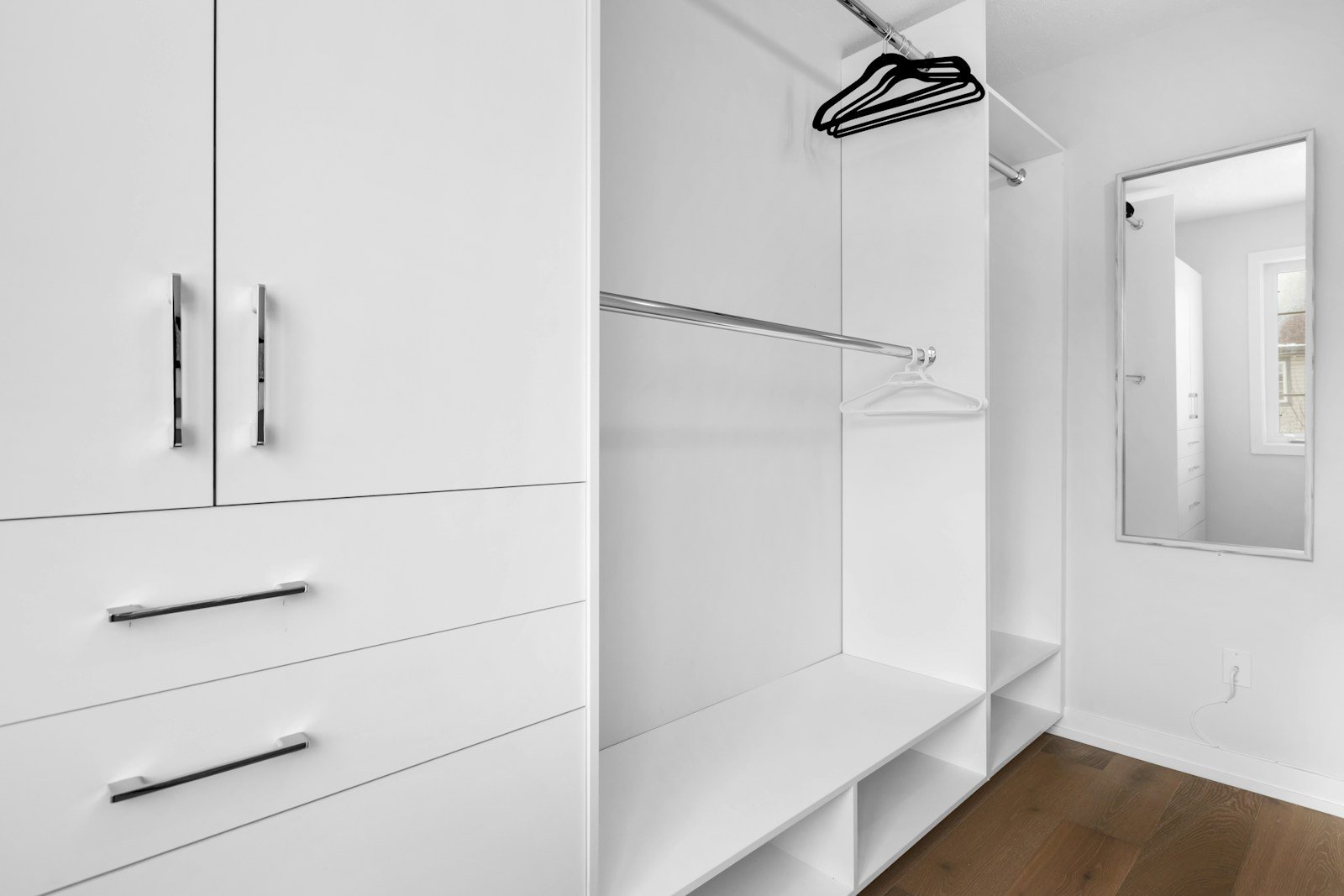 White walk-in closet with cabinets, drawers and hanging rods